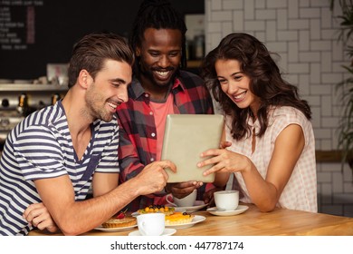 Friends using a tablet in the cafe