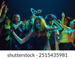 Friends in various Halloween costumes gathering at nightclub for cheerful and energetic celebration. dancing, and laughing. Concept of Halloween, holiday, party, leisure