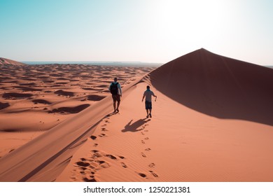 Friends walking over the sahara dunes in Morocco - Powered by Shutterstock