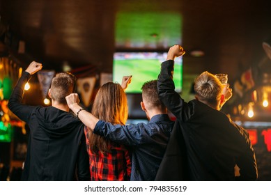 Friends watches football on TV in a sport bar - Shutterstock ID 794835619