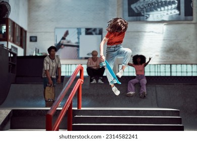 Friends watching and cheering for young woman jumping, doing skateboard stunt mid-air at skateboard park - Powered by Shutterstock