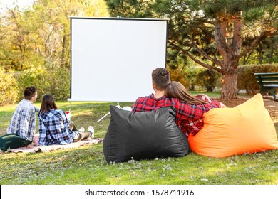 Friends Watching Movie In Outdoor Cinema