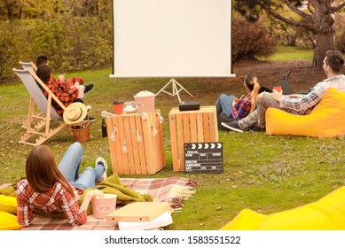 Friends Watching Movie In Outdoor Cinema