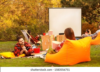 Friends Watching Movie In Outdoor Cinema