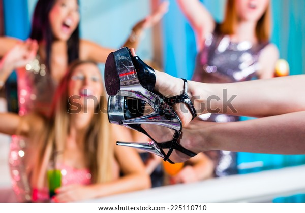 ストリップクラブでストリップを見ている友人が女性のストリッパーをつかむ の写真素材 今すぐ編集