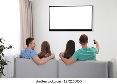 Friends Watching TV On Sofa At Home. Mockup For Design