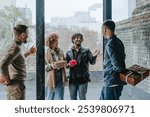 Friends welcoming guests on holiday standing with gifts near door at home. Holiday time concept.