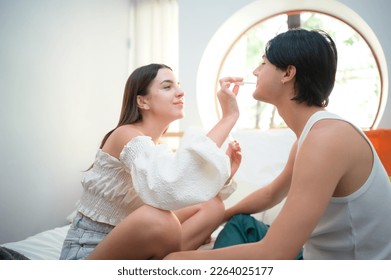 Friendship in about making up for differences. by a female friend putting lipstick on a gay friend