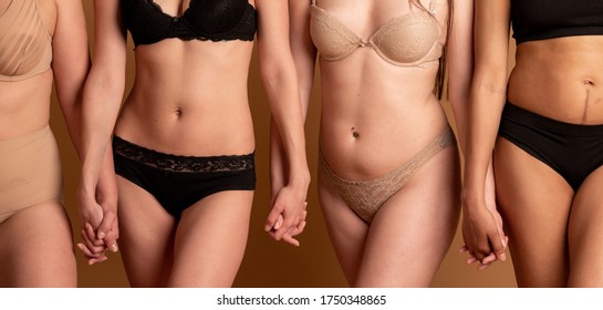 friendship, beauty, body positive and people concept - group of happy women different in underwear over gray background