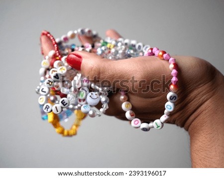 Friendship bracelets made of handmade plastic beads. Set of bright colorful braided bracelets with words. Colored ts teen jewelry.