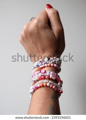 Friendship bracelets made of handmade plastic beads. Set of bright colorful braided bracelets with words. Colored ts teen jewelry.