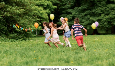 Friendship, Childhood, Leisure And People Concept - Group Of Happy Kids Or Friends Playing Tag Game At Birthday Party In Summer Park