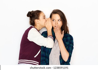 friendship, communication and people concept - happy teenage girls gossiping or sharing secrets over white background
