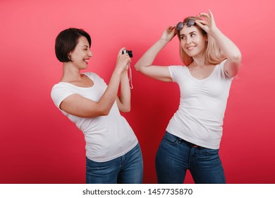 Friendship concept. Happy woman  take a picture her friend holding  photocamera - Shutterstock ID 1457735870