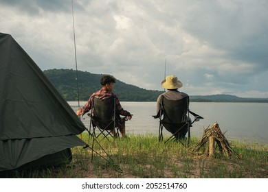 Friendship fisherman or Angler sitting a chair together and camping to fishing at the lake. Camping tent on the shore of the lake. Survival concept. - Powered by Shutterstock
