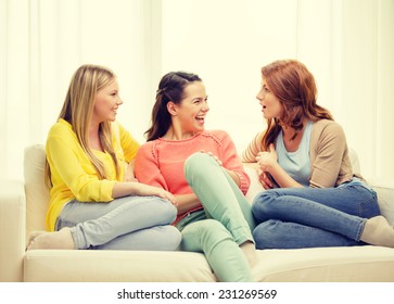 friendship and happiness concept - three girlfriends having a talk at home - Shutterstock ID 231269569
