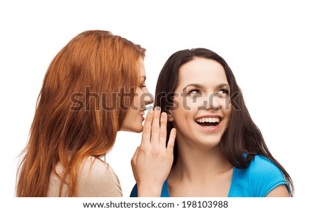 friendship, happiness and people concept - two smiling girls whispering gossip