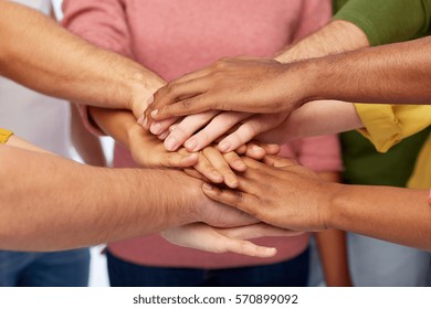 friendship, international, teamwork and people concept - close up of hands on top of each other