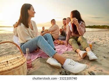 friendship, leisure and fast food concept - group of happy friends eating sandwiches or burgers at picnic on beach in summer - Powered by Shutterstock