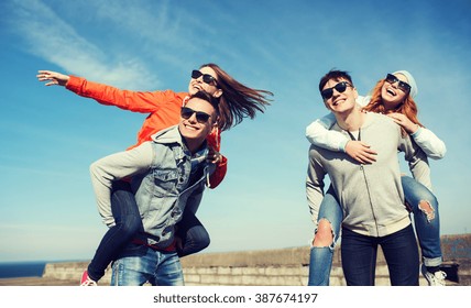 Friendship, Leisure And People Concept - Group Of Happy Teenage Friends In Sunglasses Having Fun Outdoors