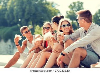 friendship, leisure, summer and people concept - group of smiling friends in sunglasses sitting with food on city square - Powered by Shutterstock