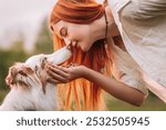 friendship and love between man and dog. red-haired girl and a beautiful Australian Shepherd dog. the girl leaned over to the dog and they touched each other’s noses