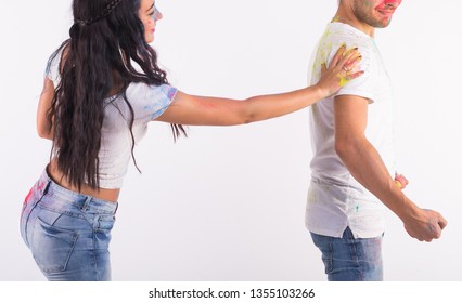 Friendship, love, festival of holi, people concept - young couple playing with colors at the festival of holi on white background - Shutterstock ID 1355103266