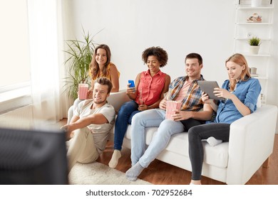 Friendship, People, Technology And Entertainment Concept - Happy Friends With Tablet Pc Computer And Smartphone Eating Popcorn, Drinking Beer Or Cider And Watching Tv At Home