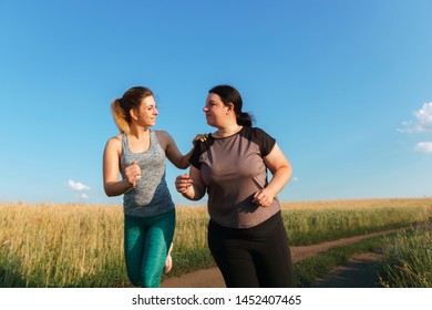 Friendship, Personal Trainer, Group Workout, Weight Loss, Sports And Health Care. Young Fit Woman Support And Motivate Her Overweight Female Friend At Outdoor Jogging