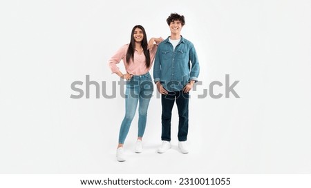 Friendship And Relationship. Full Length Shot Of Happy Young Couple Posing Together Standing Over White Studio Background. Brunette Boyfriend And Girlfriend Advertising Offer For Youth. Panorama