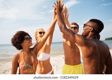 Friendship, Summer Holidays And People Concept - Group Of Happy Friends Making High Five On Beach