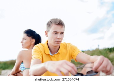 Friendship, Summer Holidays, Relations, Break Up And People Concept - Unhappy Couple Sitting On Beach