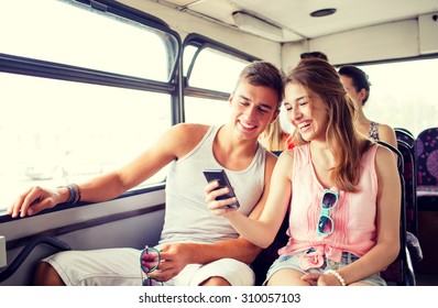 friendship, summer vacation, transport, technology and people concept - smiling couple with smartphone traveling by bus and making selfie