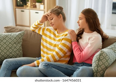 friendship, support and people concept - teenage girl comforting her sad friend at home