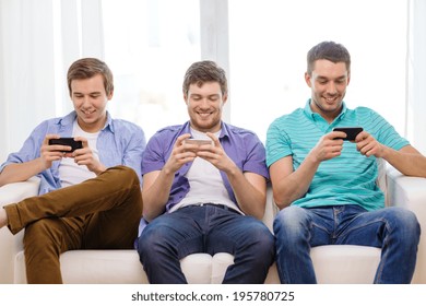 friendship, technology and home concept - smiling male friends with smartphones at home - Powered by Shutterstock