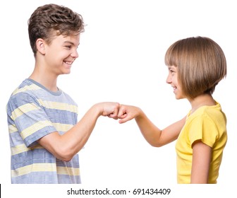 Friendship teen boy and girl are banging their fists. Portrait of happy brother and sister  fist bump isolated on white background. Funny couple children gesturing and greeting.