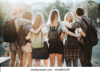 Friendship, togetherness, traveling, vacation, holidays, togetherness, sightseeing, city tour, student exchange program. Young people with backpacks standing close hugging admiring the city view - Powered by Shutterstock