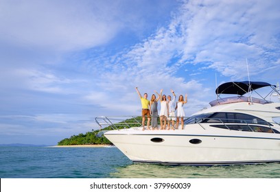 Friendship and vacation. Happy young people standing on the yacht deck and enjoying the view, sailing the sea.
