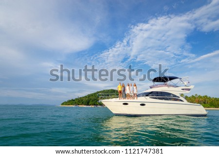 Friendship and vacation. Happy young people standing on the yacht deck and enjoying the view, sailing the sea.