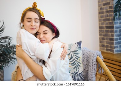 Friendship, Youth, Love And Care Concept. Happy Beautiful Sisters Bonding At Home, Embracing Each Other Gently. Two Female Best Friends Hugging, Sitting On Bed, Glad To Finally See One Another