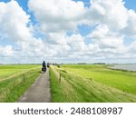 Friesland, Netherlands, August 8th 2023: Cycling on a small trail along a dyke