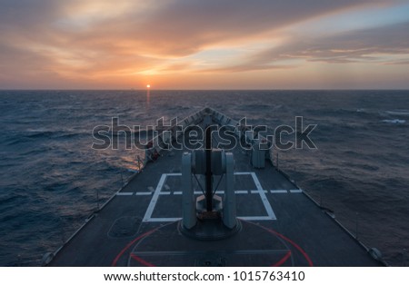 A frigate bow during sunset at sea. A stormy sea during sunset in a navy frigate.