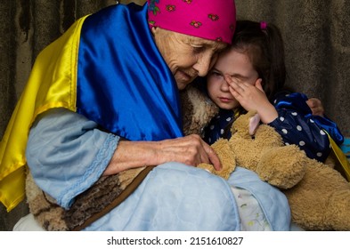 Frightened child during the war.An old woman in a bomb shelter.Grandmother plays with a child in the basement during the war.Childhood during the war. War in Ukraine.Russian aggression against Ukrаine
