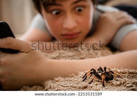 A frightened child with a tablet saw a terrible huge spider on the bed. Arachnophobia.