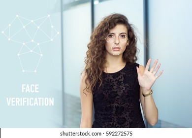 Frightened curly girl holds open hand, face verification. Scanning of personal data.