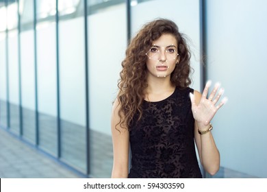 Frightened curly girl holds open hand, biometric verification. Preservation and identity theft.