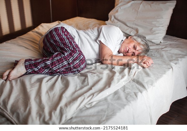 Frightened depressed\
middle aged woman lying alone on bed in fetal position covering\
feeling afraid or depressed suffer from insomnia mental problem\
abuse violence\
concept