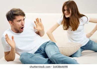 Frightened man closes his hands from an angry woman - Shutterstock ID 1643864698