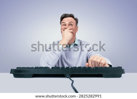 Frightened man sitting at a computer and covering his mouth with his hand in shock and fear while using a keyboard. Concept of panic, anxiety, stress, surprise, fear, alarming news, unexpected information, shocking events, bad news, internet communication, online content, cyber threats, work stress and emotional reaction to something disturbing seen on a computer screen.