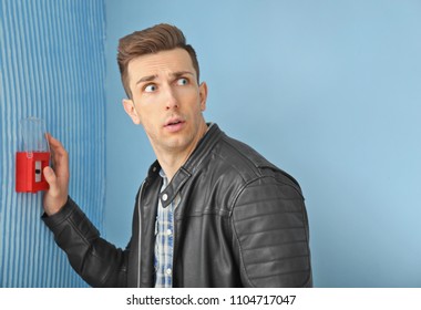 Frightened man using fire alarm system indoors